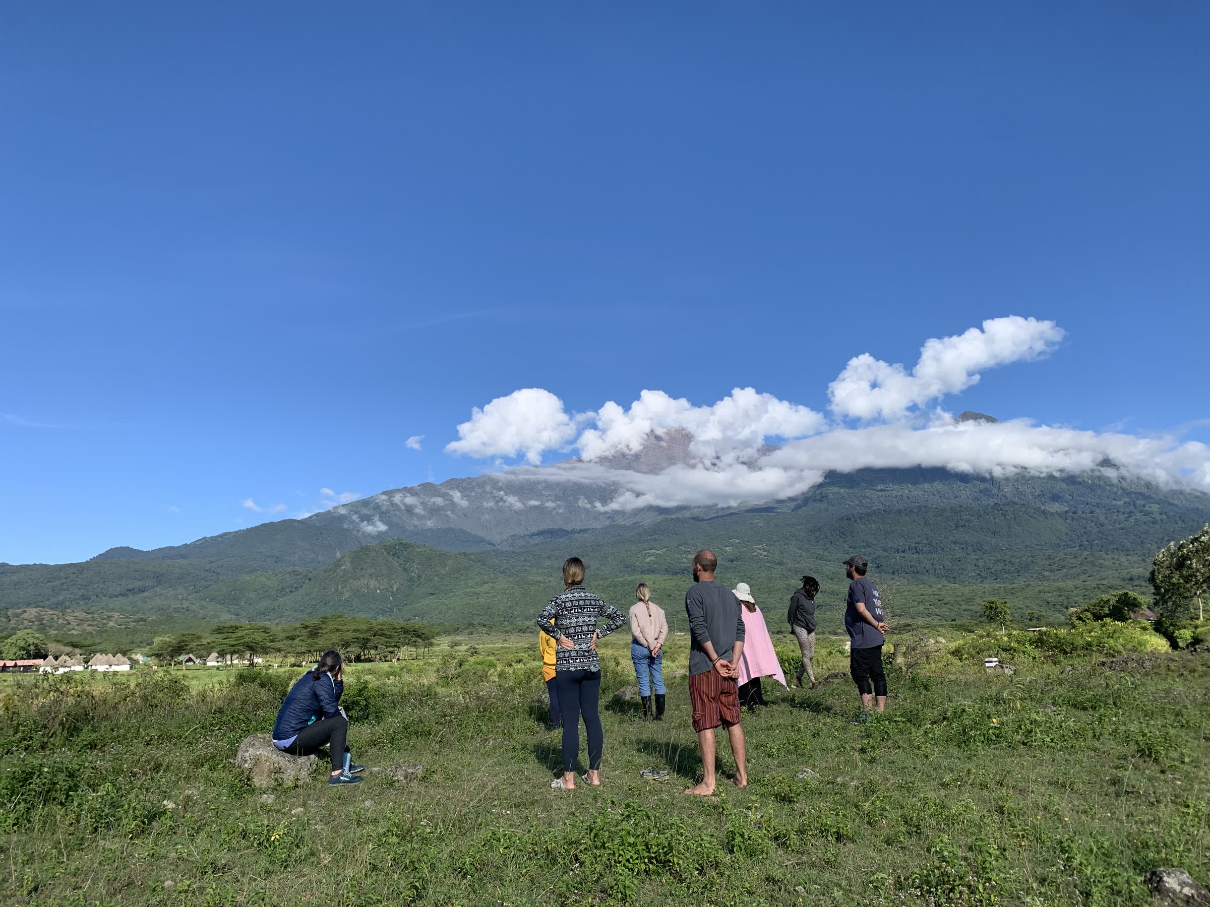 A retreat group standing together before Mount Meru